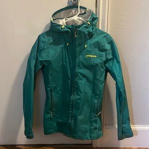 Patagonia woman’s rain jacket. Size small. Green with yellow zipper pulls